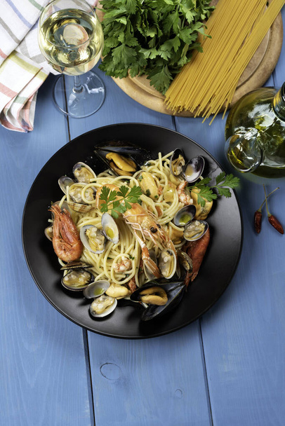 Dish of delicious spaghetti allo scoglio, a typical italian pasta with scampi, shrimp, mussel and clams, mediterranean cuisine  - Photo, Image
