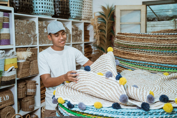 man holding knit carpet craft in the craft gallery - Foto, Bild