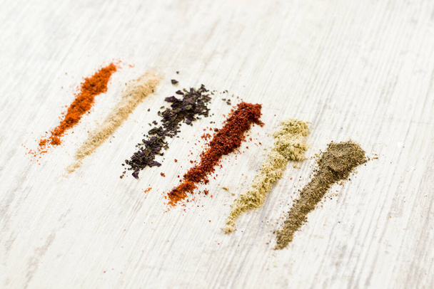 A flat lay of the variety of spices on the white table - Photo, image