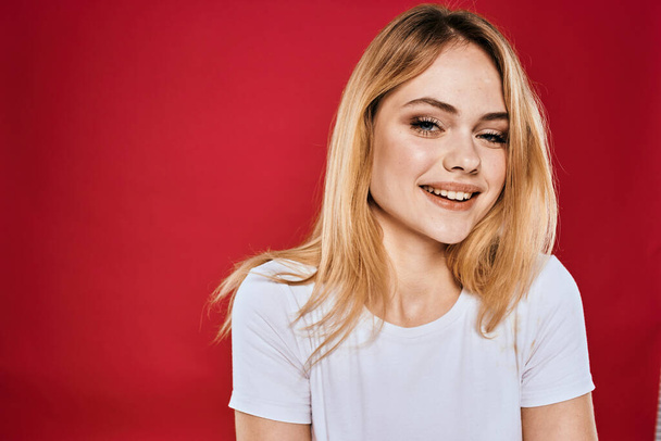 Hübsche Frau lächeln weißes T-Shirt abgeschnittene Äste roter Hintergrund - Foto, Bild
