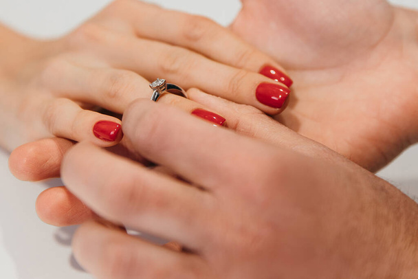 A man gently puts a ring on the finger of his beloved woman after a marriage proposal - Photo, Image