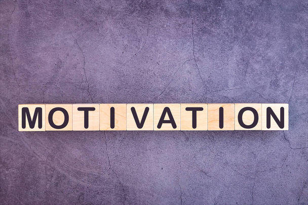 Word MOTIVATION made with wood building blocks on a gray background - Photo, Image