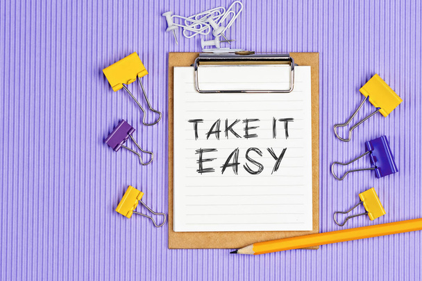 Слова Take it easy written on a white notebook. Закрытие личной программы - Фото, изображение
