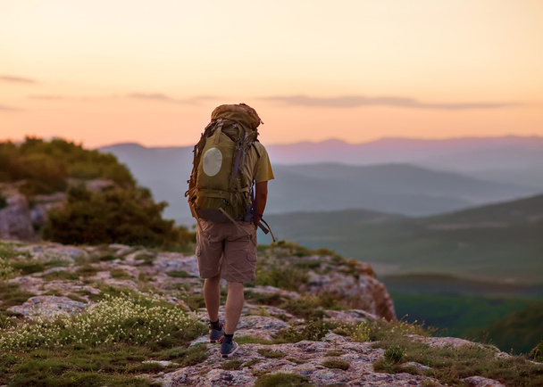 Guy in the mountains at sunset. the concept of freedom - Foto, imagen