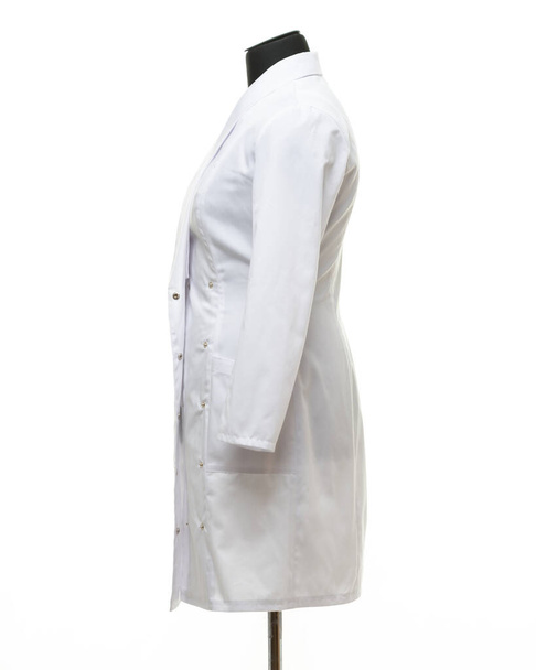 Medical gown hanging on a mannequin, side view, isolated on white background - Photo, Image
