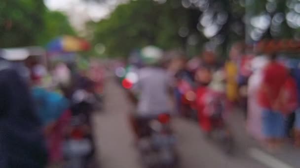 расплывчатый перефокусированный боке-вид воскресной утренней активности людей в Сурабае Индонезии вокруг Национальной Великой Мечети с людьми, собирающими, бегающими, осматривающими достопримечательности и совершающими покупки на местном временном рынке.  - Кадры, видео