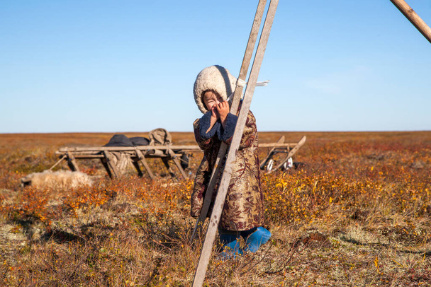 Ekstremalna północ, Yamal, przeszłość ludzi z Nenets, zamieszkanie narodów północy, dziewczyna bawiąca się w pobliżu jurty w tundrze - Zdjęcie, obraz