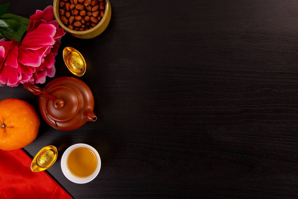 Flache Lage chinesisches Neujahr Mandarine Orange und Teewasser mit Draufsicht auf schwarzer Farbe hölzerne bakcground.Copy Raum für China-Fest feiern. - Foto, Bild