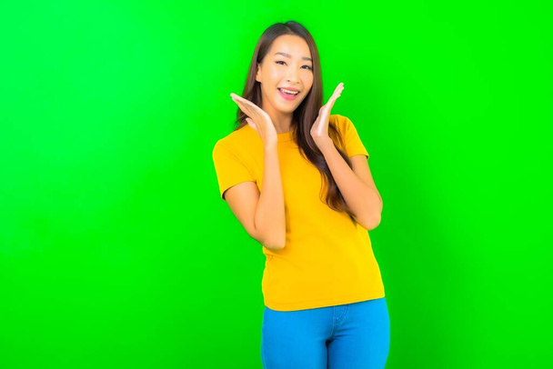 Retrato bonito jovem asiático mulher sorriso com ação no verde isolado fundo - Foto, Imagem