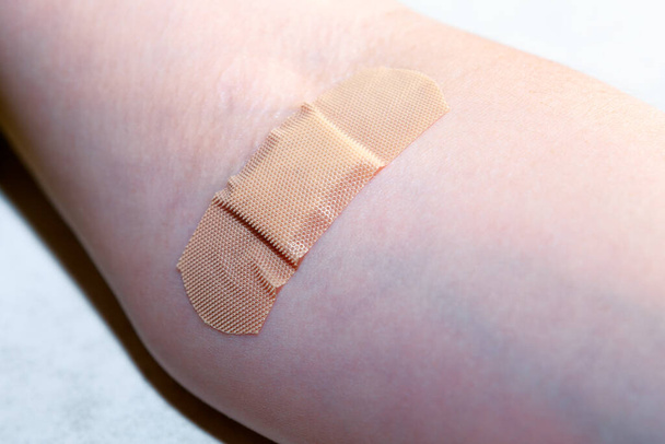 Пластырь на руке после прохождения анализов крови - Фото, изображение