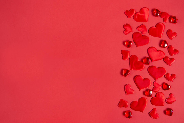 Kırmızı zemin üzerinde kırmızı kalpler olan tebrik kartı. Sevgililer Günü tatili konsepti. Düz yat, boşluğu kopyala. - Fotoğraf, Görsel