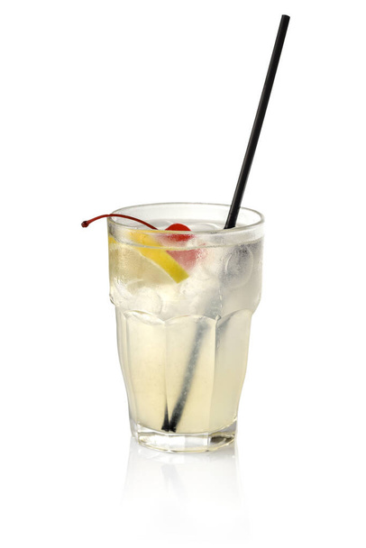 Коктейль из джина с ломтиком лимона, сахарной вишней, кубиками льда и черной соломой в стекле на белом фоне - Фото, изображение
