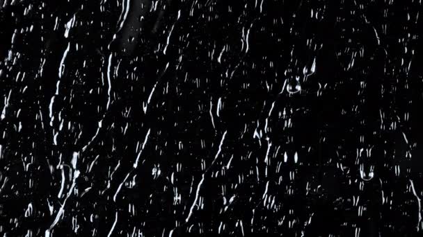 Images au ralenti 4k de gouttes d'eau sur fond de verre noir - Séquence, vidéo