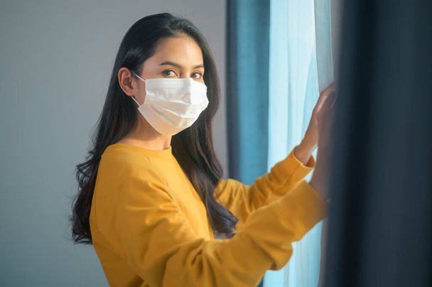 A young beautiful woman wearing a protective facial mask getting ready to go outside, Healthcare and covid-19 concep - Foto, imagen