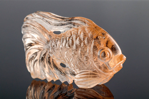hermoso pez figurín hecho de topacio sobre un fondo gris de cerca - Foto, Imagen