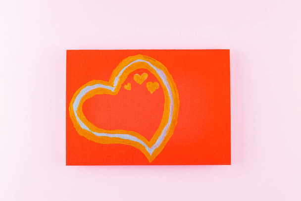 Heart of gold paints on a red postcard. Festive card with hearts on a pink background. Valentine s day postcard. Copy space. Top view - Valokuva, kuva