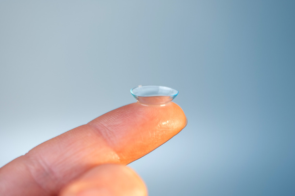 Işık arkaplanındaki parmakta kontakt lens - Fotoğraf, Görsel