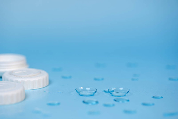 contact lenses on blue background with water drops - Photo, Image