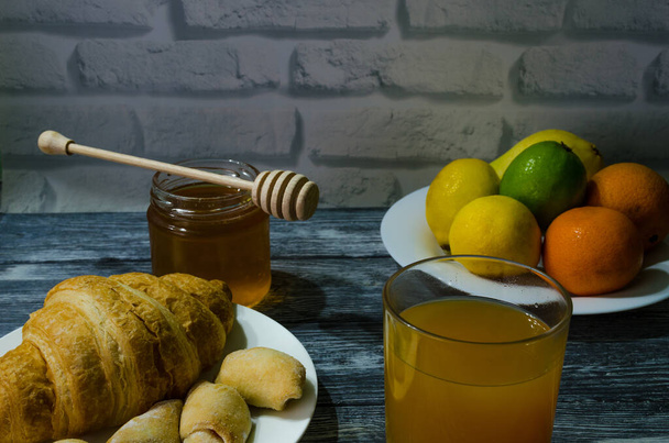 Натюрморт со свежими фруктами и стаканом сока на деревянном фоне - Фото, изображение