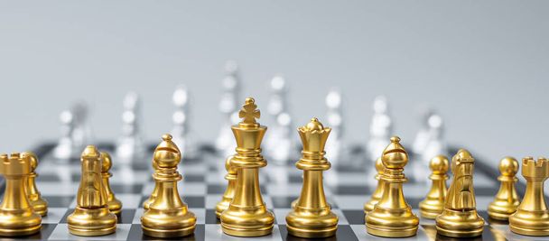 Gold Chess figuurteam (Koning, Koningin, Bisschop, Ridder, Rook en Pion) op Schaakbord tegen tegenstander tijdens de strijd. Strategie, Succes, management, bedrijfsplanning, tactiek, politiek en leiderschapsconcept - Foto, afbeelding