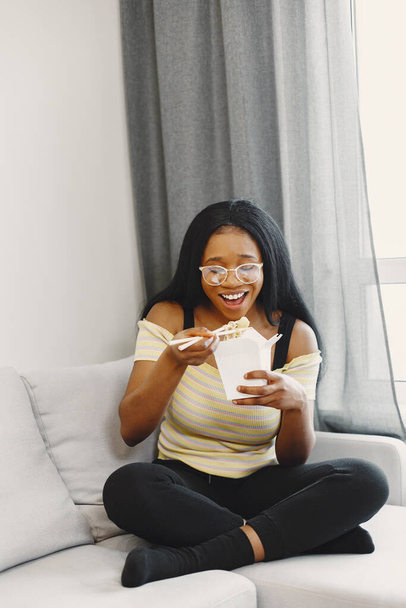 Beautiful young african american woman eating noodles - Foto, Imagen
