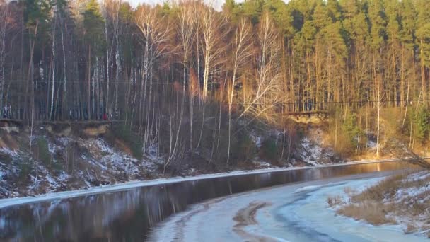 Auringonlasku puiden takana jäätynyt joki - Materiaali, video