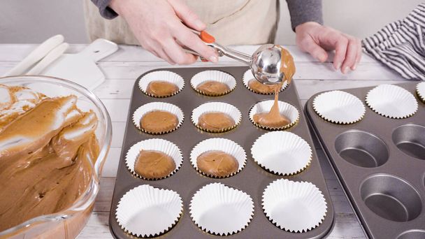 Escavar massa nos forros de cupcake de papel alumínio para assar cupcakes de framboesa de chocolate. - Foto, Imagem