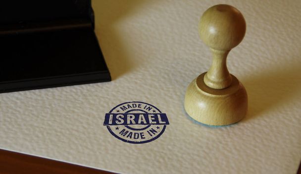 Φτιαγμένο στο Ισραήλ σφραγίδα και το χέρι σφράγισης. Έννοια της χώρας παραγωγής, παραγωγής και παραγωγής. - Φωτογραφία, εικόνα