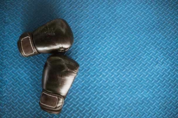 black boxing gloves on blue iron flooring - Фото, зображення
