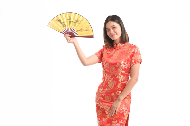 Asiatin in chinesischem Kleid hält am chinesischen Neujahrstag einen kleinen gelben Fächer in der Hand. - Foto, Bild