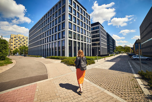 Mooie vrouw toeristische wandelingen door Wroclaw Polen op de achtergrond van moderne architectuur gebouwen in het business center - Foto, afbeelding