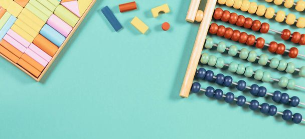 Bebé niños juguetes fondo. Abacus y cubos de madera sobre fondo azul claro. Vista superior - Foto, imagen
