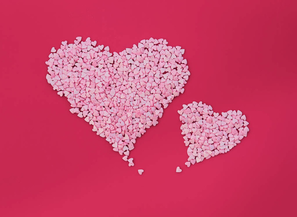 Two big hearts made of small hearts on red background. Love minimal concept - Foto, Bild