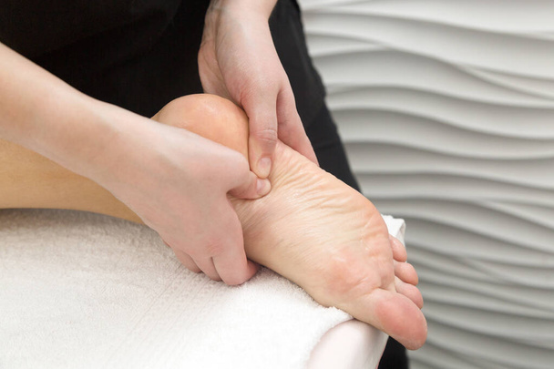 Massage the heels and feet of a person's leg. - Fotoğraf, Görsel