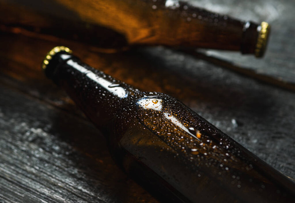 Zimne piwo w szklanych butelkach na drewnianym stole - Zdjęcie, obraz