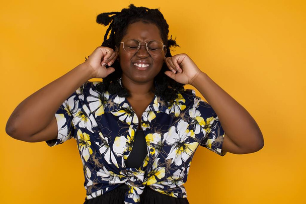 Fejezd be ezt az idegesítő hangot! Fejlövés a boldogtalan stresszes, fiatal afro-amerikai nő alkalmi ruhát, hogy aggódni arc, dugulás fülek ujjaival, irritált hangos zaj jön a szomszédok, akik élnek felette. - Fotó, kép