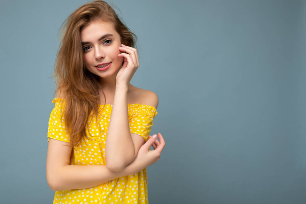Fiatal vonzó szőke nő személy őszinte érzelmek elszigetelt háttér fal másolási hely visel nyári sárga ruhát. Pozitív koncepció - Fotó, kép