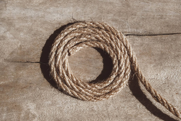 Thick rope on old wooden background. Top view. Copy, empty space for text.. - Photo, Image