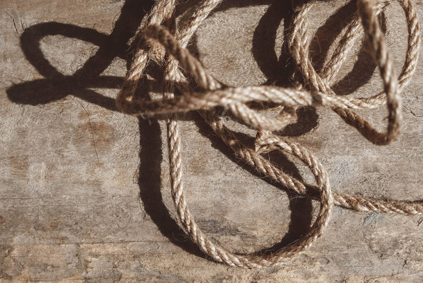 Thick rope on old wooden background. Top view. Copy, empty space for text.. - Фото, изображение