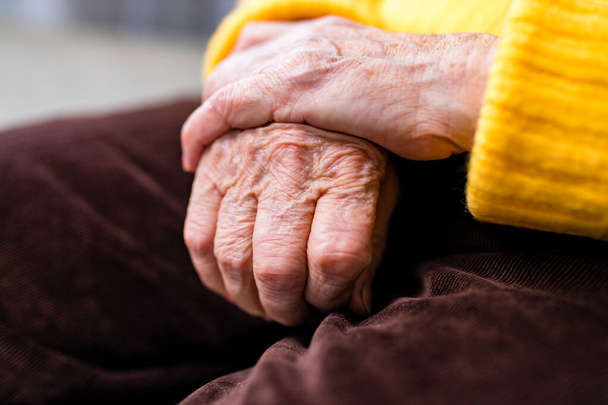 old senior woman hands wrinkled skin close up on knees - Fotó, kép