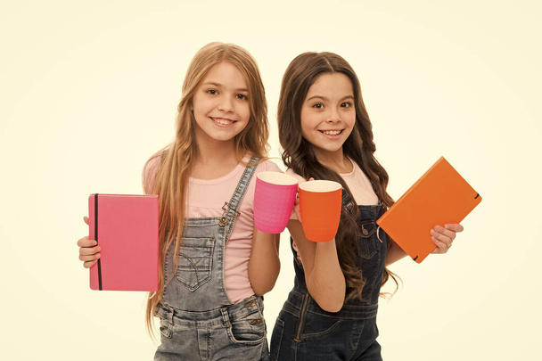 More energy. Girls cute children long hair drink cocoa or tea. Schoolgirls with mugs having tea break. Relax and recharge. Water balance concept. Enjoying tea together. Sisters or friends drink water - Zdjęcie, obraz