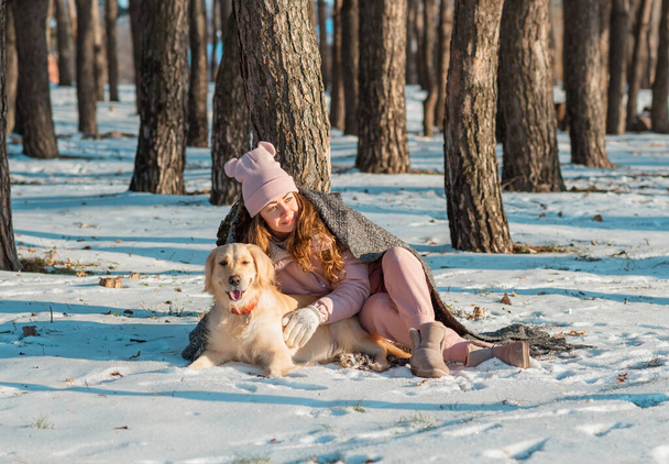 Giovane femmina godere l'inverno con cane golden retriever nella neve - Foto, immagini