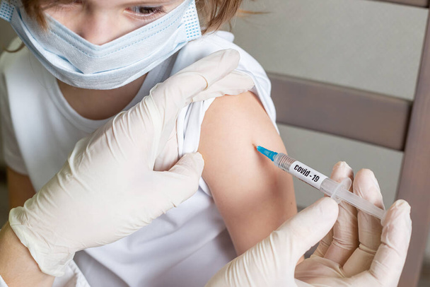 Doctor holding syringe with Covid-19 or coronavirus vaccine. Medical worker vaccinating child coronavirus. - Zdjęcie, obraz