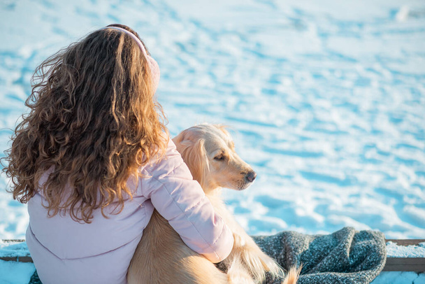 Retrato de jovem bela mulher sentada e abraçando seu cão golden retriever. Felicidade e amizade. animal de estimação e mulher. Visão traseira - Foto, Imagem