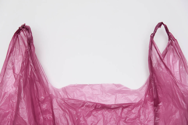 Handles of a red plastic bag on white background - Fotografie, Obrázek