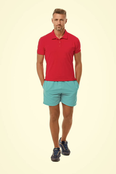 Sport style. Menswear and fashionable clothing. Man calm face posing confidently white background. Man looks handsome in shirt and shorts. Guy sport outfit. Fashion concept. Man model clothes shop - Fotó, kép