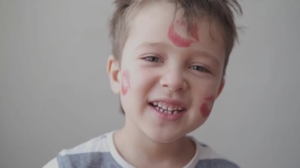 Cute little boy with many lipstick kisses on face sing valentine day. Close up. - Footage, Video