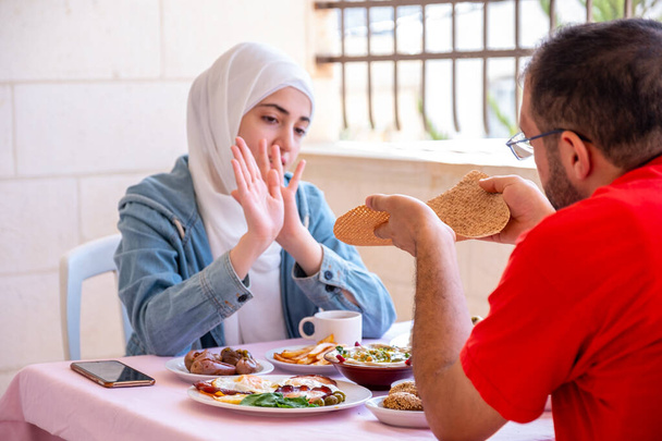 Çiftler birlikte kahvaltı yapıyor ve kız ekmeği almayı reddediyor. - Fotoğraf, Görsel