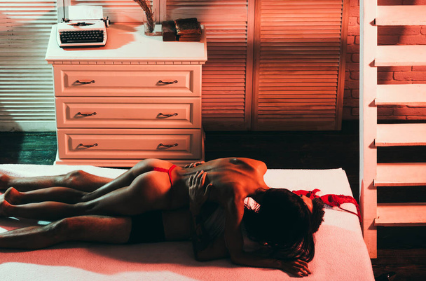 Couple relaxing in bed. Young and cocky lovers. Adult. Portrait of happy loving couple. Sensual woman with body in red lace erotic lingerie with muscular man. Loving everything about her. - Foto, Imagem