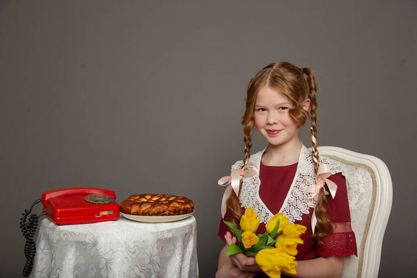 Cute schoolgirl girl with flowers and pie - Zdjęcie, obraz